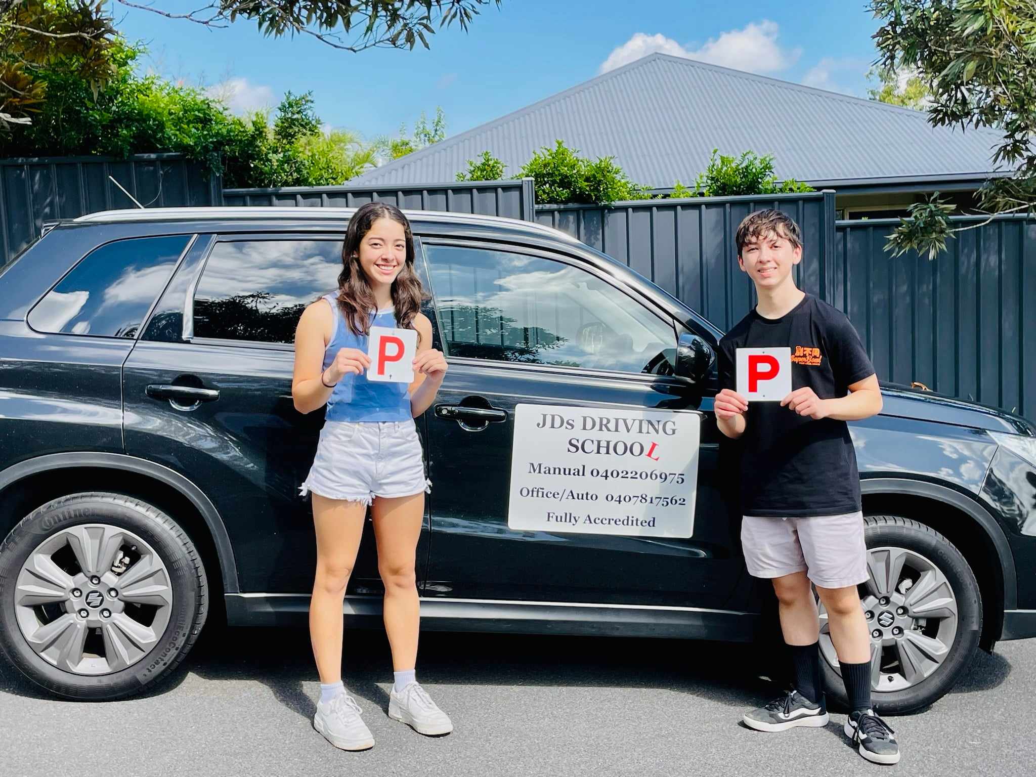 Happy learner holding a passed driving test certificate from JDS Driving School.